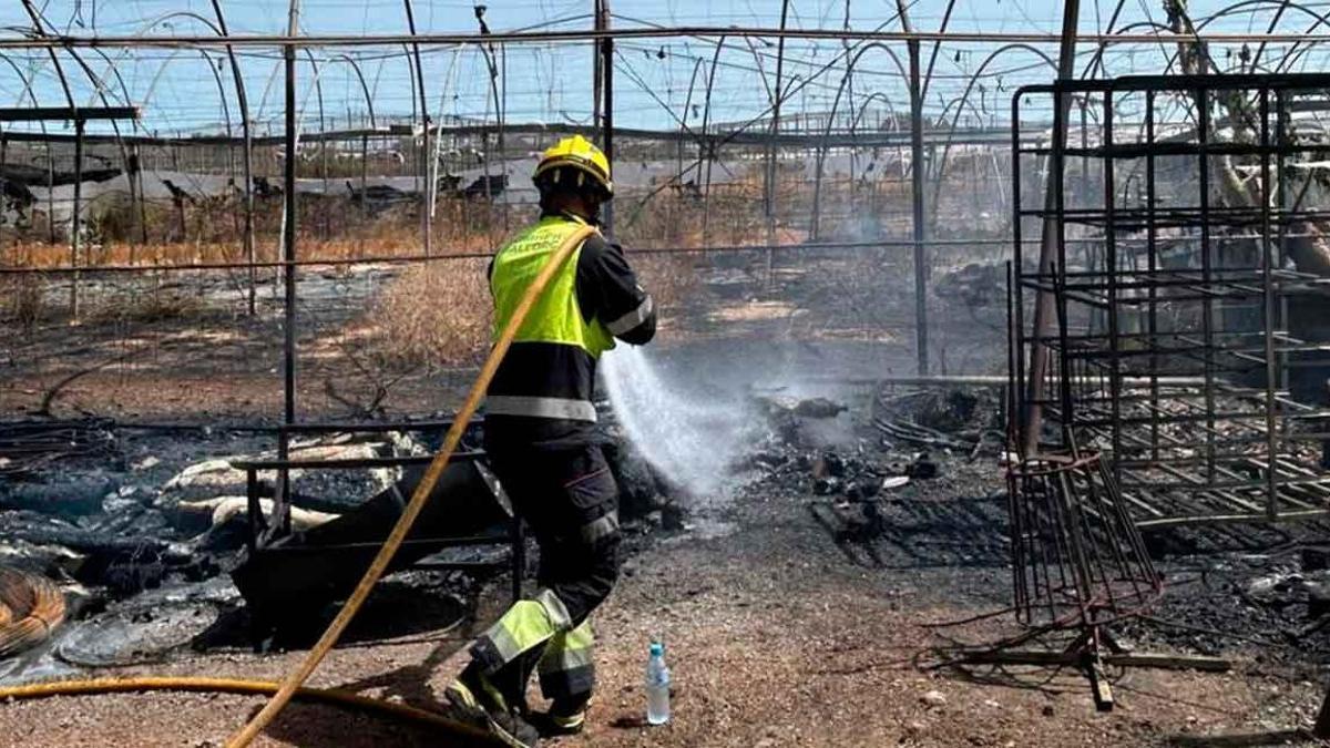 Un bombero refresca la zona incendiada.