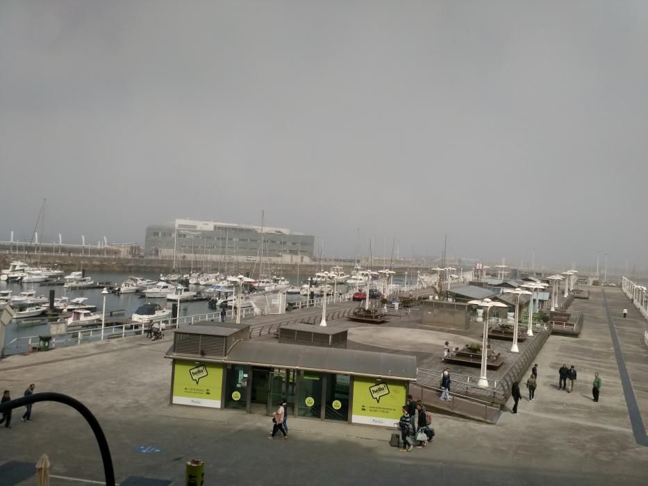 La bruma chafa el día de sol en la costa de Gijón.