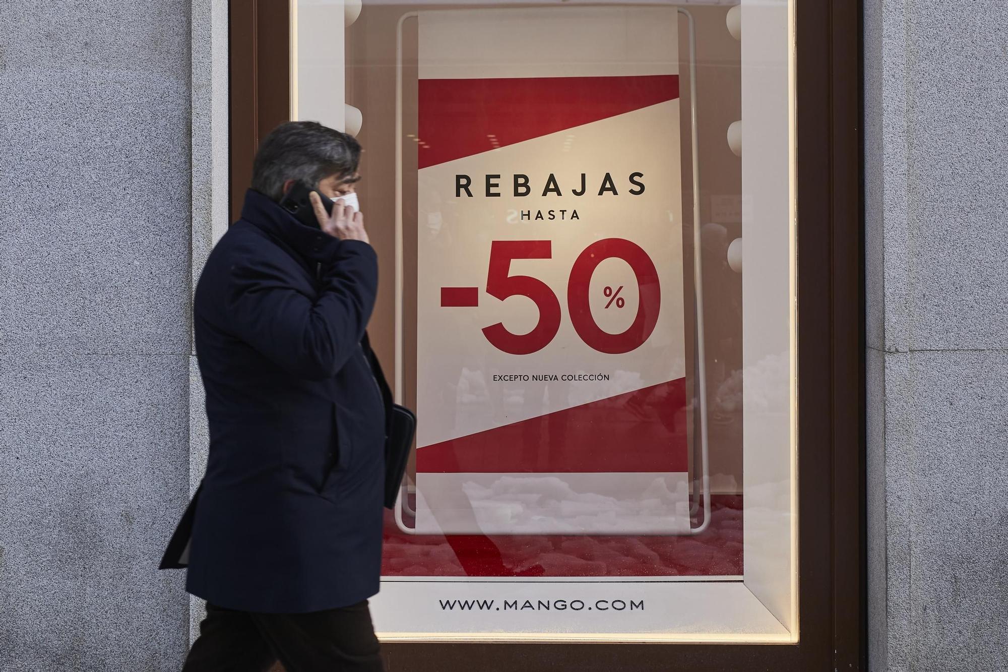 Un hombre camina frente a un cartel de rebajas en Madrid.