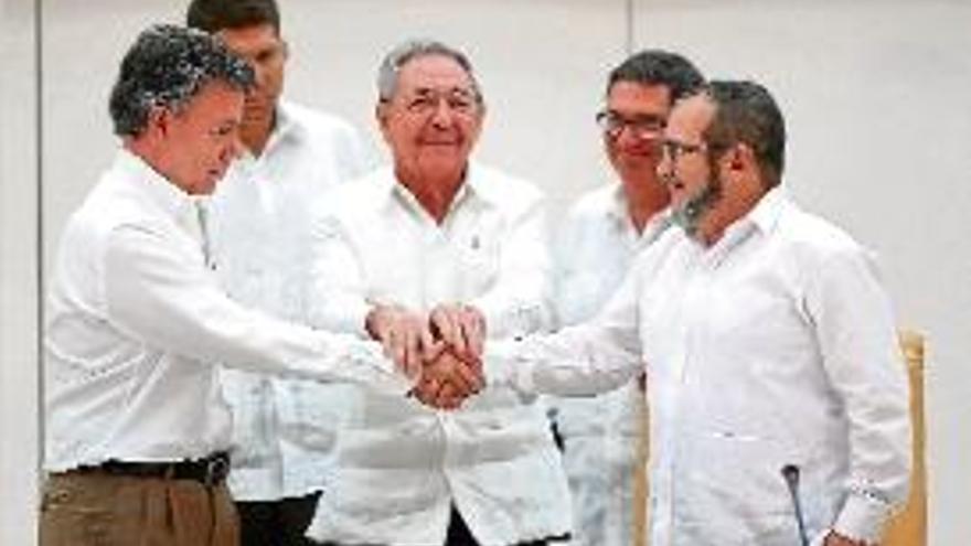 Santos i Timochenko encaixen les mans en presència de Castro.