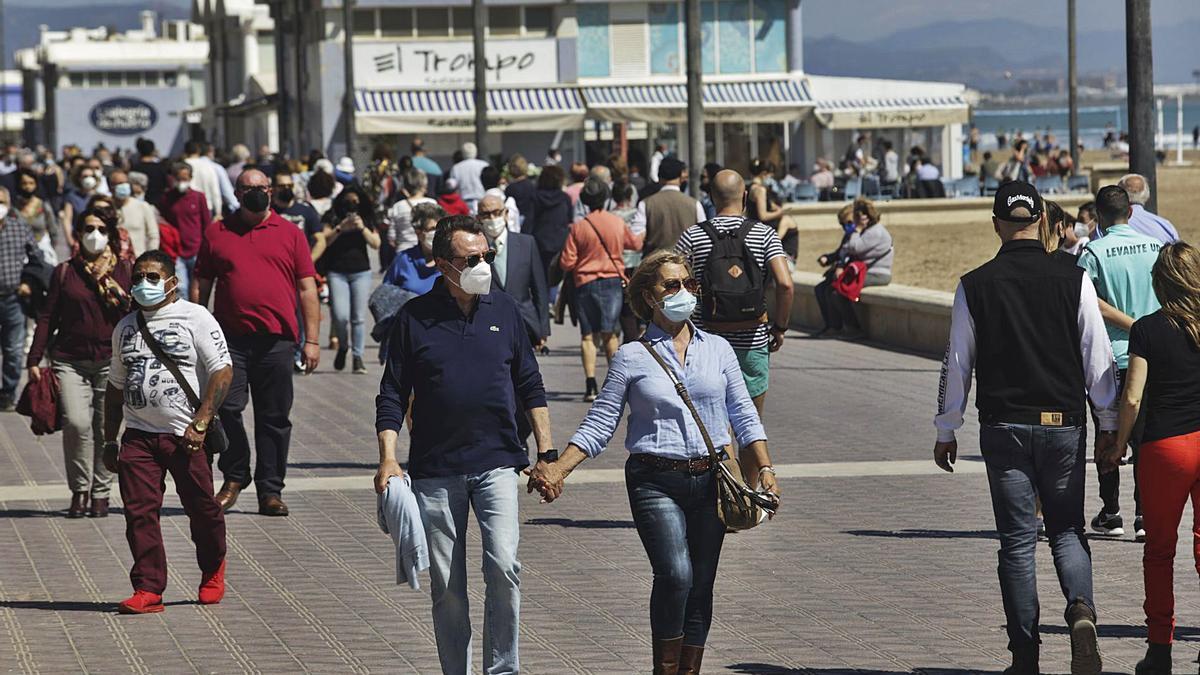 Muchos valencianos aprovecharon las buenas temperaturas de ayer para disfrutar de la «nueva normalidad» en el paseo marítimo. | EDUARDO RIPOLL