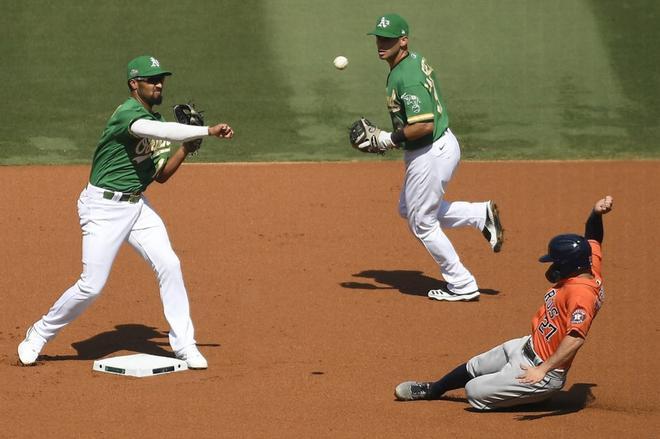 Marcus Semien # 10 de los Atléticos de Oakland expulsa a José Altuve # 27 de los Astros de Houston en la segunda base durante la primera entrada en el Juego Dos de la Serie Division de la Liga Americana en el Dodger Stadium.