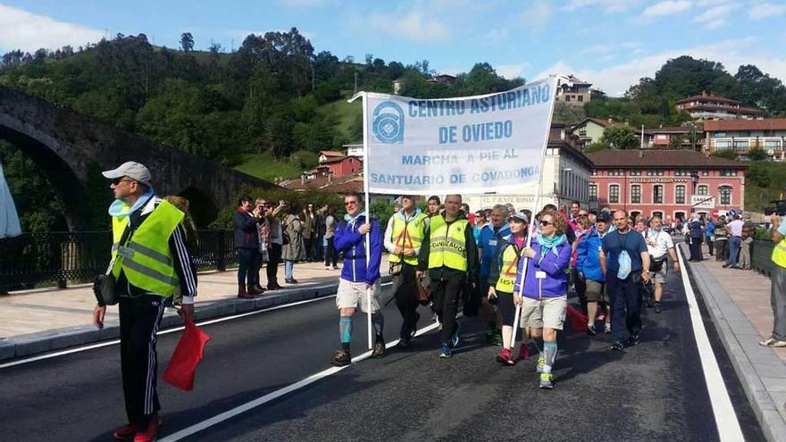 Participantes en la marcha a pie a Covadonga, a su paso por Cangas de Onís, en una edición anterior.