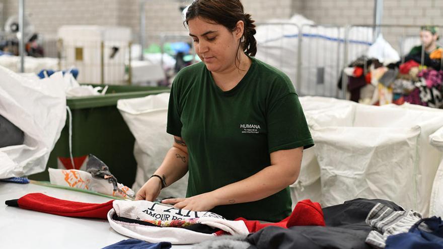 Una treballadora a la planta de triatge de roba de  la Fundació Humana