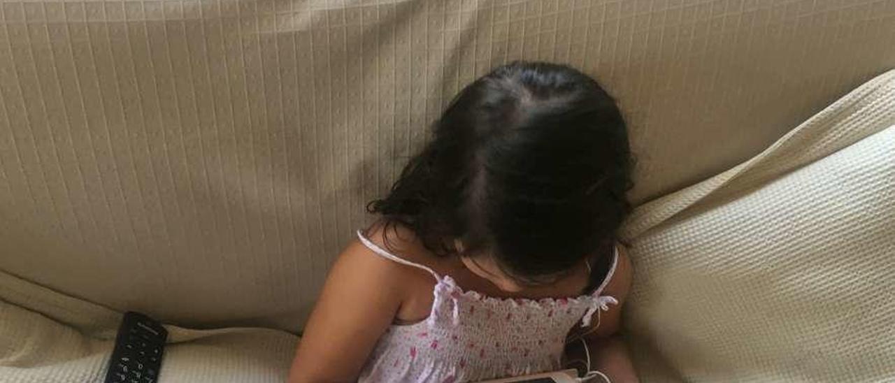 Una niña juega con una tableta. // FdV