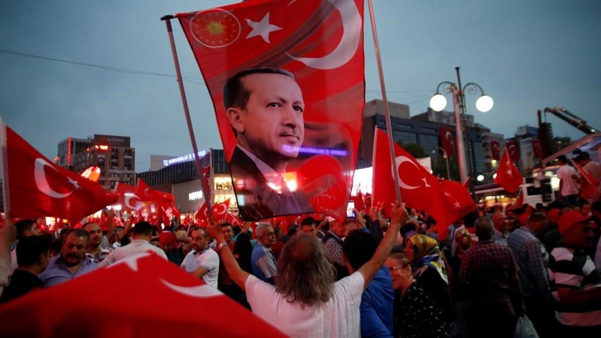 Un seguidor de Erdogan sostiene una bandera con una imagen del presidente turco, en una marcha progubernamental, en Ankara, el 20 de julio.