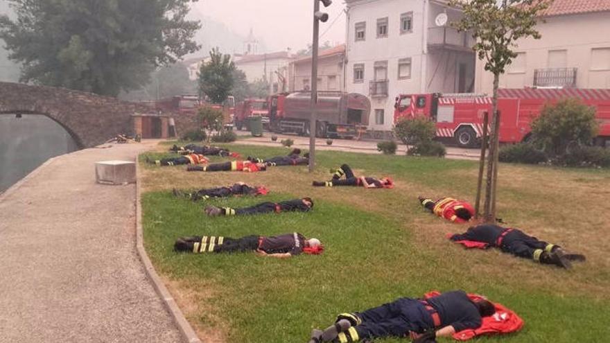Foto de los bomberos exhaustos de combatir el fuego en un descanso.