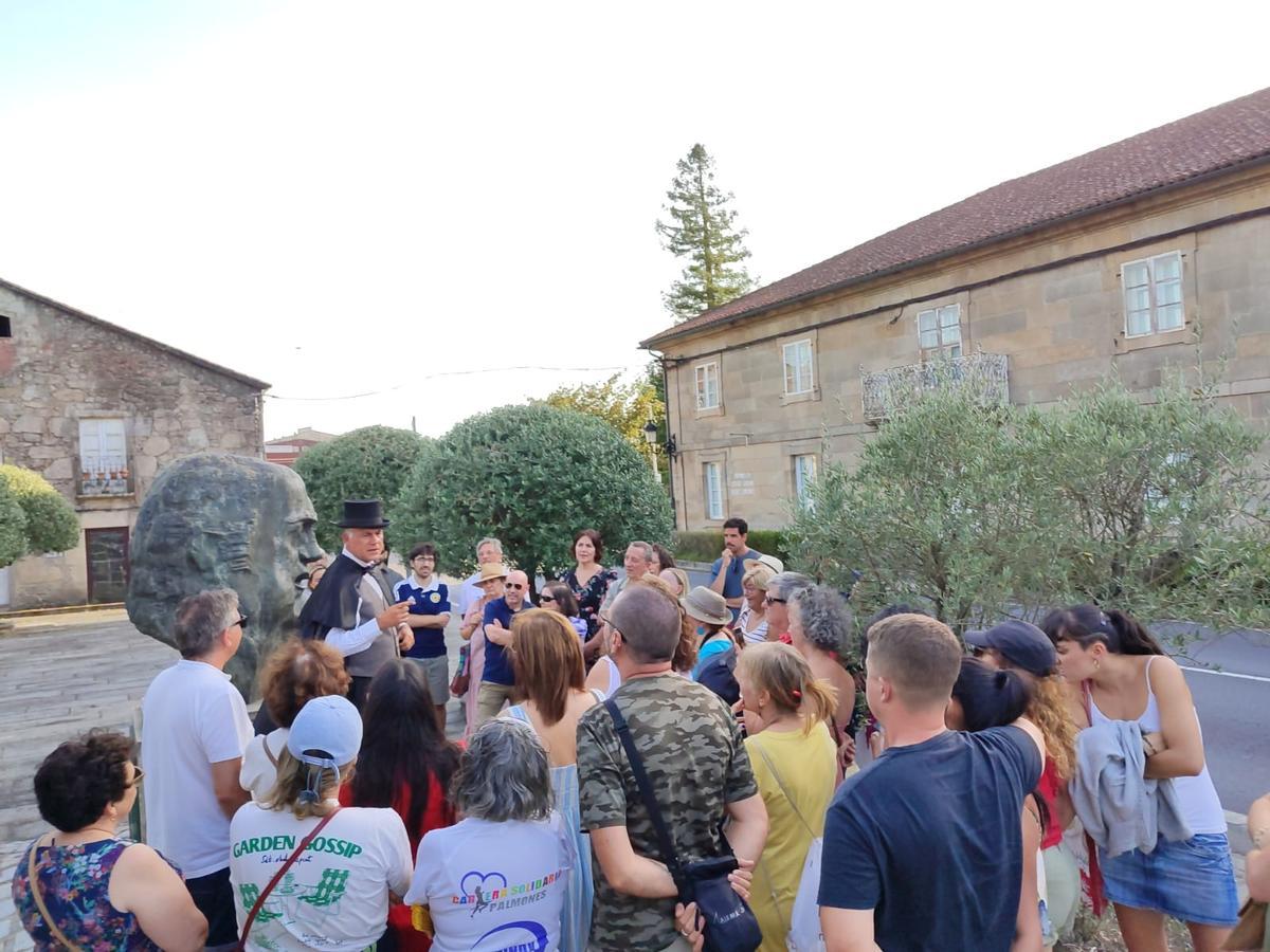Turistas atienden a un guía durante una visita en Padrón.