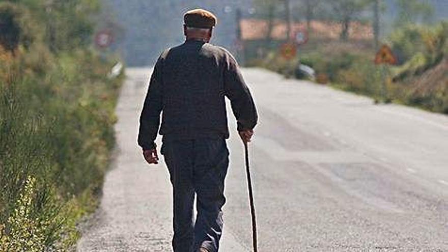 Un hombre camina por el arcén de una carretera.