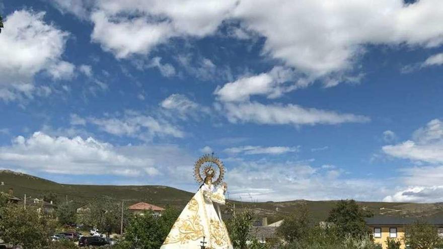 Un grupo de mujeres cargan a sus hombros a la Virgen Peregrina en la procesión por Donado.