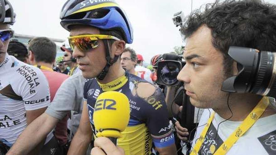 Alberto Contador atiende a un periodista en la línea de meta con el maillot roto tras sufrir una caída en la primera etapa del Tour.