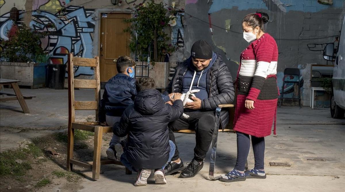 Barcelona     09 12 2020      Barcelona   Valentin y su mujer Ceracela junto a su dos hijos  pendientes en la foto de su mascota  fotografiados en el interior de La Escocesa  una de las naves en el Poblenou donde conviven okupando alrededor de cincuenta familias pendientes de su realojamiento por parte del Ajuntament     Fotografia de Jordi Cotrina