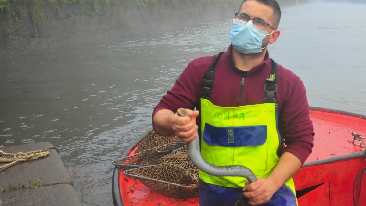 Ramón Agrasar, uno de los pescadores, con una lamprea en sus manos.