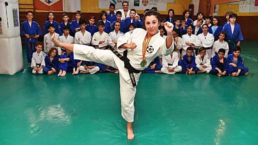 Rebeca Garrán, con su medalla de oro, en el gimnasio del Judo Club Coruña con todos sus alumnos detrás.