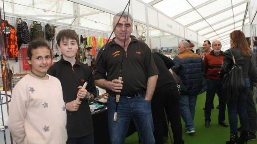 Noemí García, José García Boto y José Luis García, con unas cañas fluviales en la Feria del Salmón.