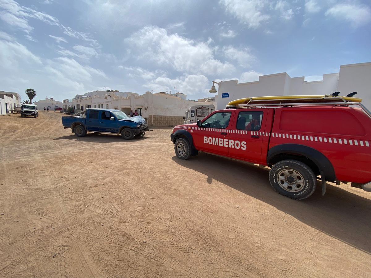 Un vehículo de los bomberos del Consorcio de Seguridad y Emergencias de Lanzarote junto a los dos coches accidentados en La Graciosa.