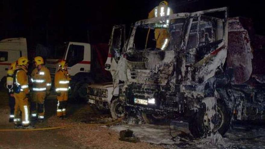 Los bomberos anoche durante las tareas de extinción junto a los vehículos calcinados.