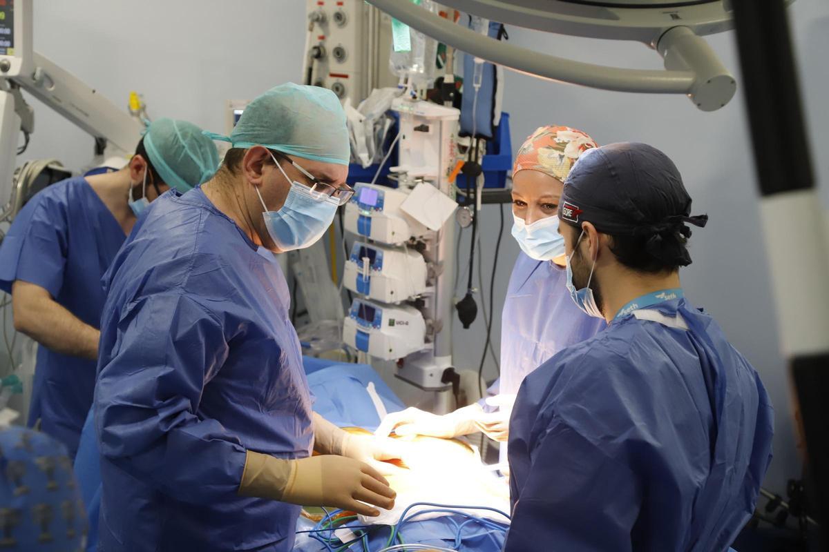 A la izquierda, Javier Briceño, jefe de Cirugía General y Digestiva del hospital Reina Sofía, usando cirugía robótica con otros compañeros.