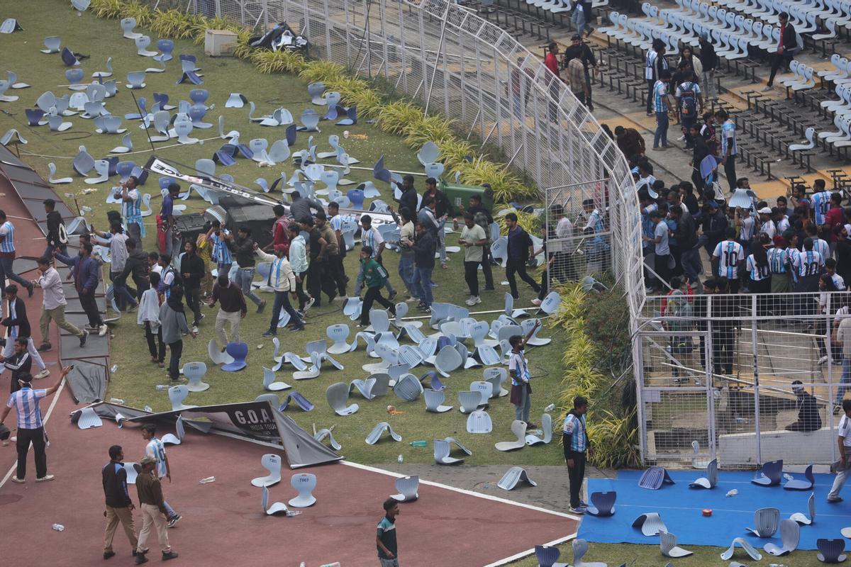 FOTODELDÍA CALCUTA (INDIA), 13/12/2025.- Aficionados lanzan botellas, sillas y vandalizan vallas publicitarias en el estadio Salt Lake de Calcuta, Bengala Occidental, India, este sábado. Las fuerzas de seguridad de la India realizaron cargas policiales este sábado contra grupos de aficionados en Calcuta tras estallar disturbios generalizados por la brevedad de la visita del futbolista Lionel Messi, cuya aparición en el estadio duró apenas 22 minutos y fue calificada de estafa por los asistentes. EFE/ Piyal Adhikary