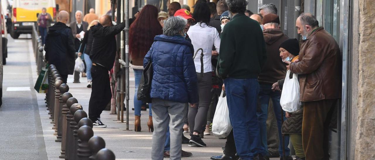 Colas ante la Cocina Económica, en la calle Socorro. |   // CARLOS PARDELLAS