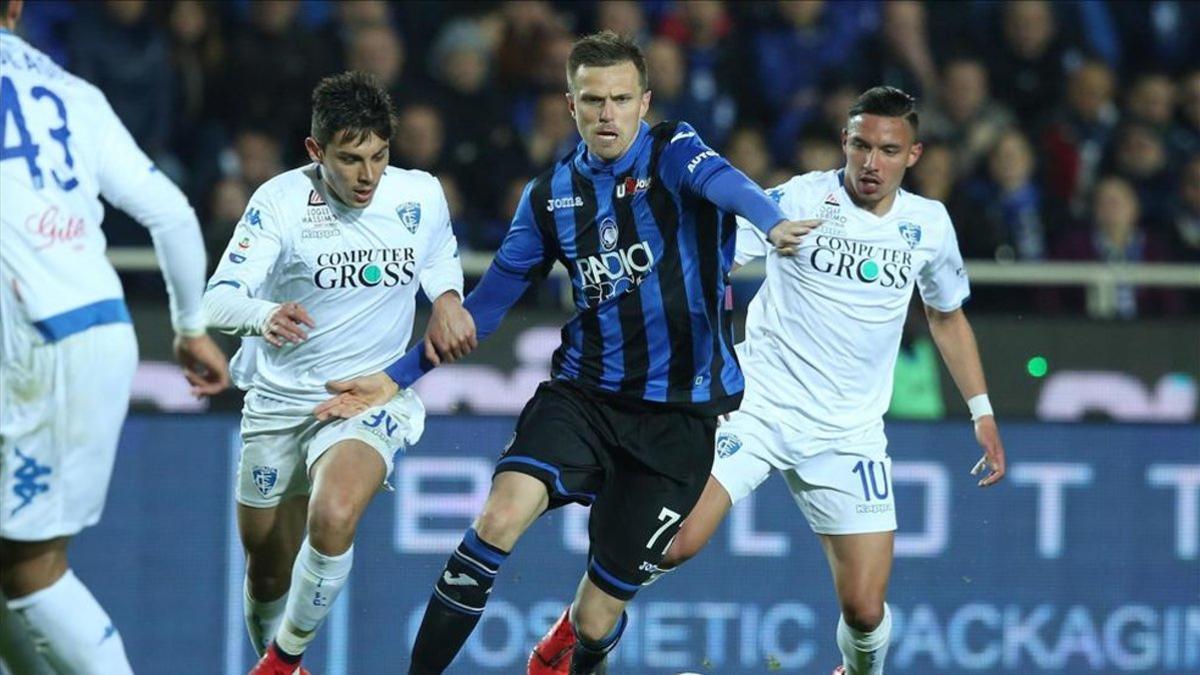 Josip Ilicic de Atalanta disputa un balón con Cristian Dell'Orco de Empoli