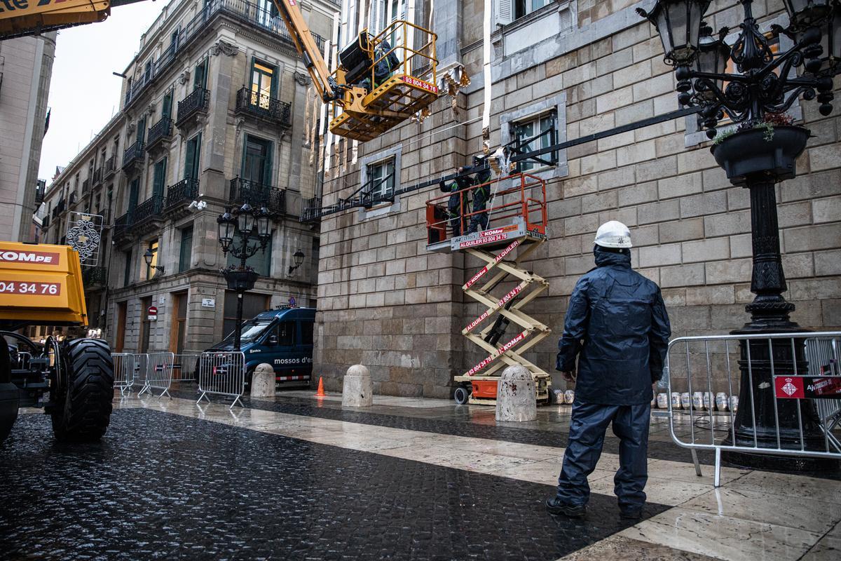 Operarios instalan partes de la decoración navideña en el Palau de la Generalitat.