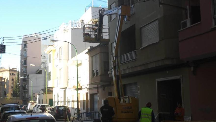 Dos técnicos y un policía local de Palma, ayer junto al elevador que enganchó dos cables eléctricos.