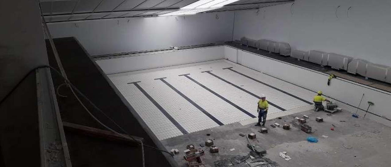 Los trabajos en el interior del vaso de la piscina de Bueu, de 25 metros de longitud.