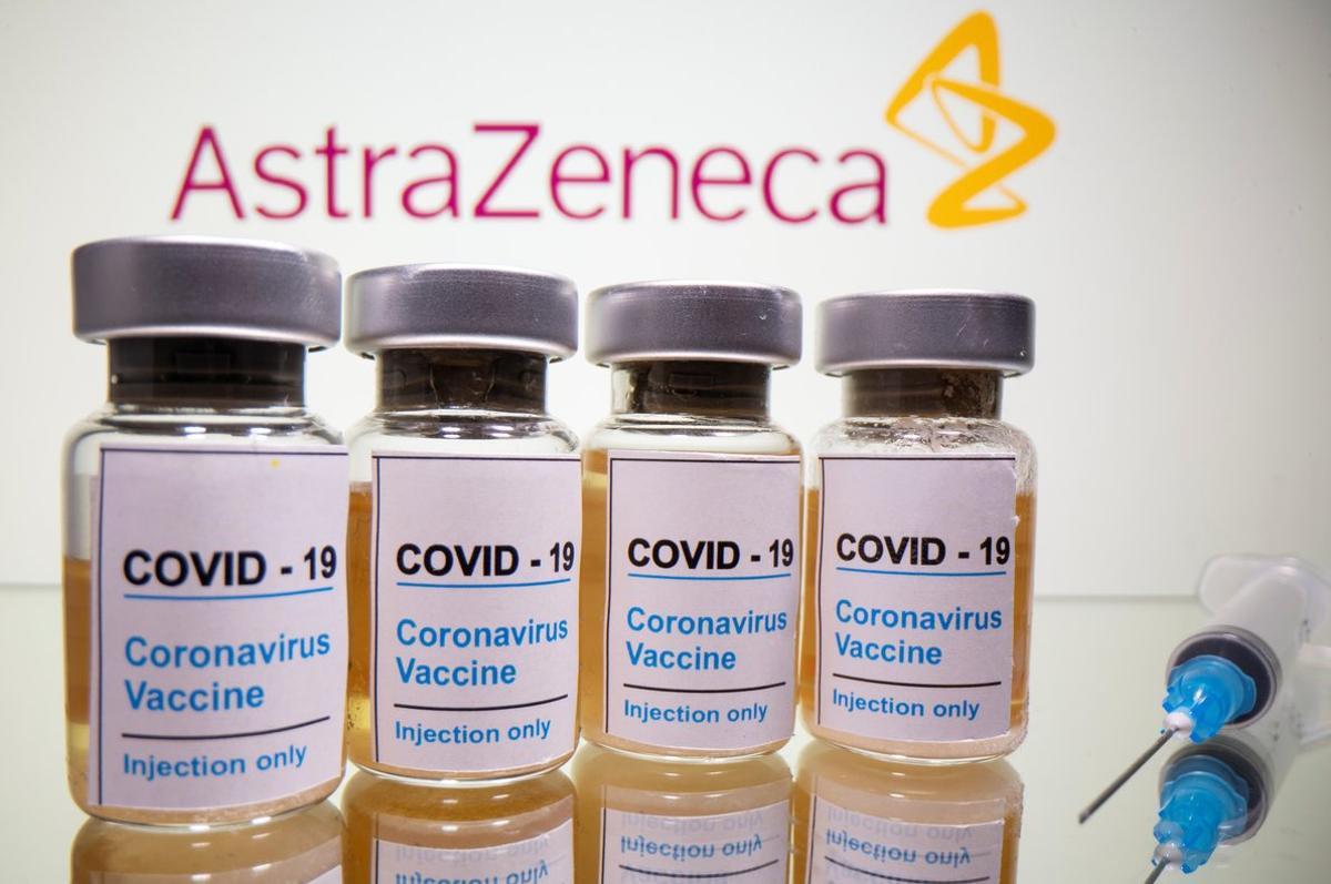 Vials with a sticker reading, COVID-19 / Coronavirus vaccine / Injection only and a medical syringe are seen in front of a displayed AstraZeneca logo in this illustration taken October 31, 2020. REUTERS/Dado Ruvic/Illustration