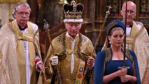 El rey Carlos III de Gran Bretaña camina con la corona de San Eduardo .