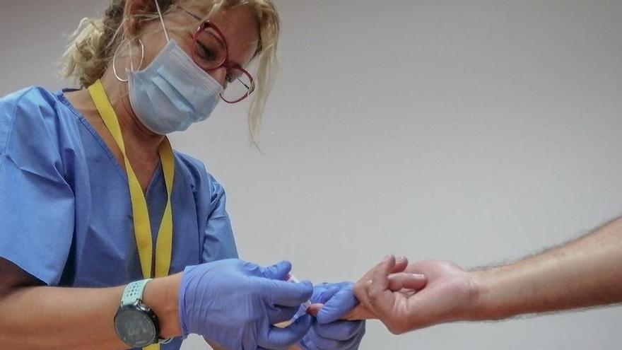 Una sanitaria toma una muestra de sangre de los test rápidos de Covid-19 que se realiza a los docentes, que afrontarán  la actividad presencial en los centros escolares. En el Hospital Militar de Sevilla.