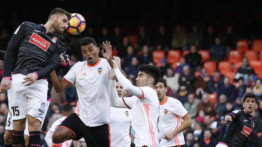 David López remata ante el defensa del Valencia Aderlan.