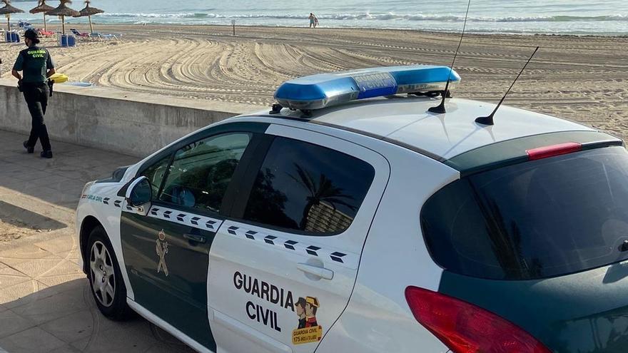 Una agente y un vehículo de la Guardia Civil en una playa de Mallorca. Archivo.