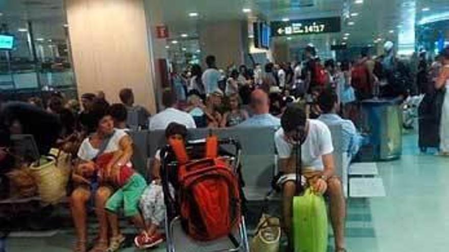 Varios pasajeros del avión con destino Asturias, en el aeropuerto de Ibiza.