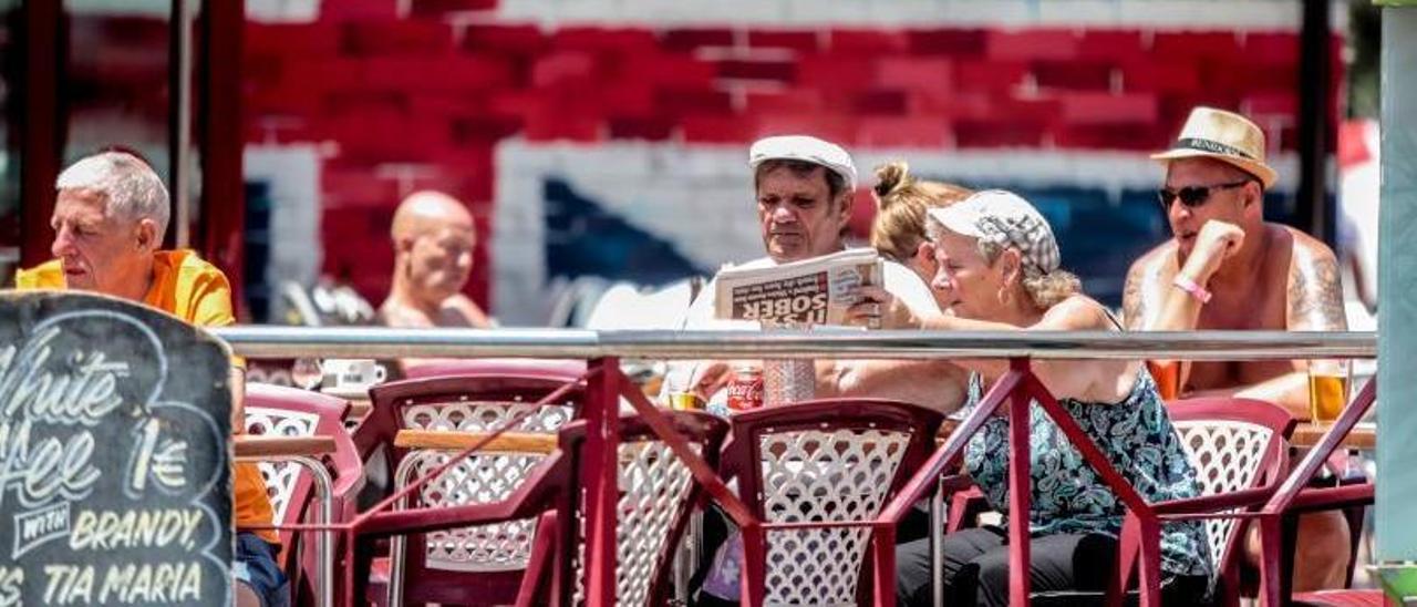 Britische Touristen, die eine englische Zeitung in Benidorm im Dateibild konsultieren.