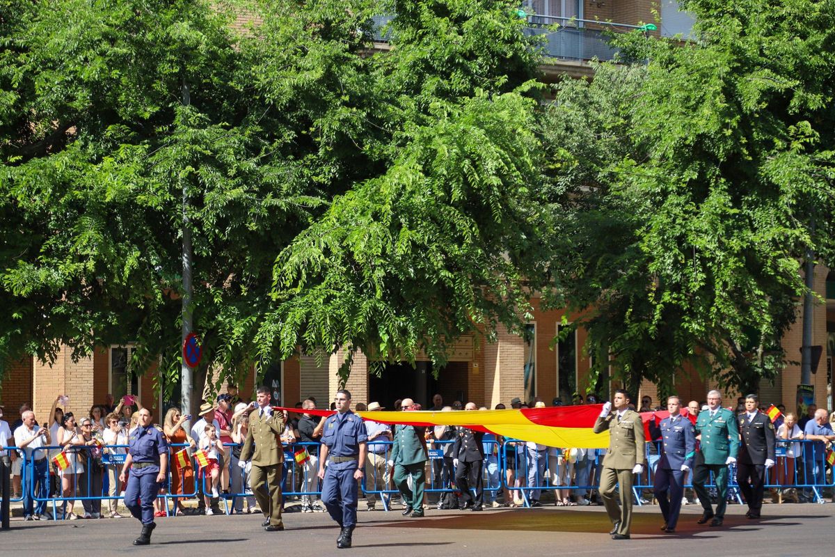 Miembros de la Brigada Extremadura XI; el Ala 23, la Guardia Civil y la Policía Nacional portan la bandera para ser izada.