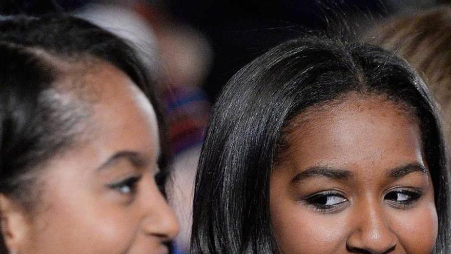 Barack Obama y su hija Malia, acompañados de Santa Claus y otros invitados tras encender el árbol navideño. Abajo, Michelle Obama junto al personaje infantil Miss Piggy.