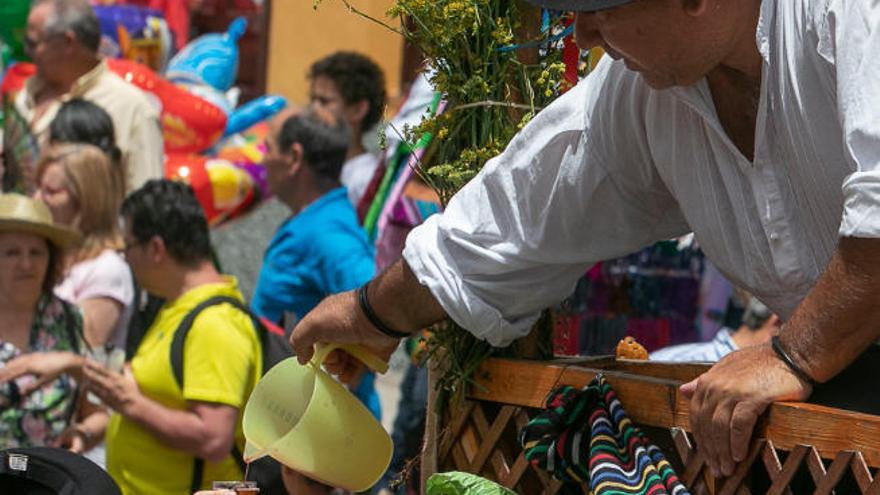 Dos personas emplean vasos de cristal en la romería de San Benito.