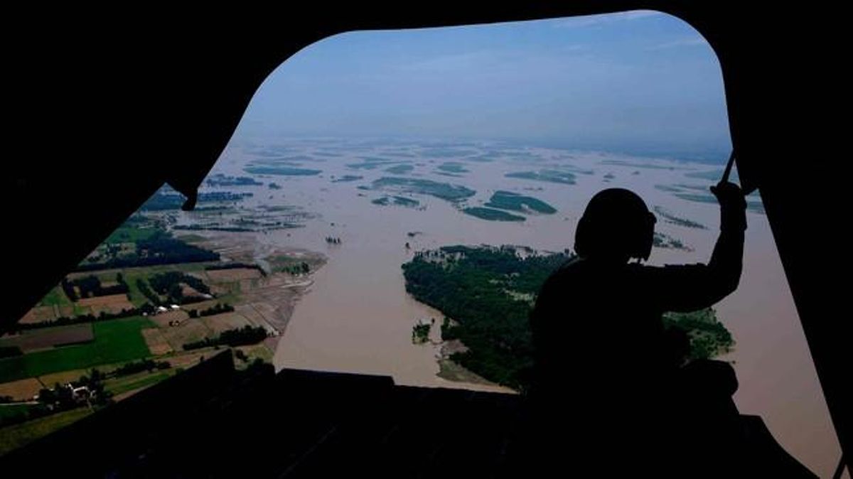 Un helicòpter nord-americà sobrevola una àrea inundada per fer arribar menjar als afectats.