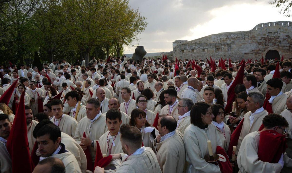 Distintos momentos de la espera de los hermanos del Silencio, algunos muy jóvenes, antes de iniciar la procesión. Debajo, a la derecha, salida del pebetero de la Torre del Salvador.