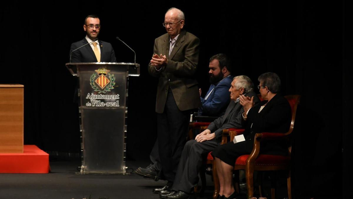 Llorens Bort, de pie, aplaude durante la ceremonia de los Premis 20 de Febrer del 2019, al lado del alcalde, José Benlloch..