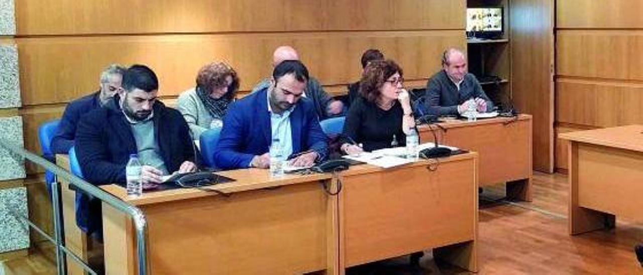 Sobre estas líneas David Alonso y Lourdes Moure (PSOE). Atrás a la derecha, Manuel Carrera (UDDL). en un pleno municipal. |   // ALFREDO HERNÁNDEZ