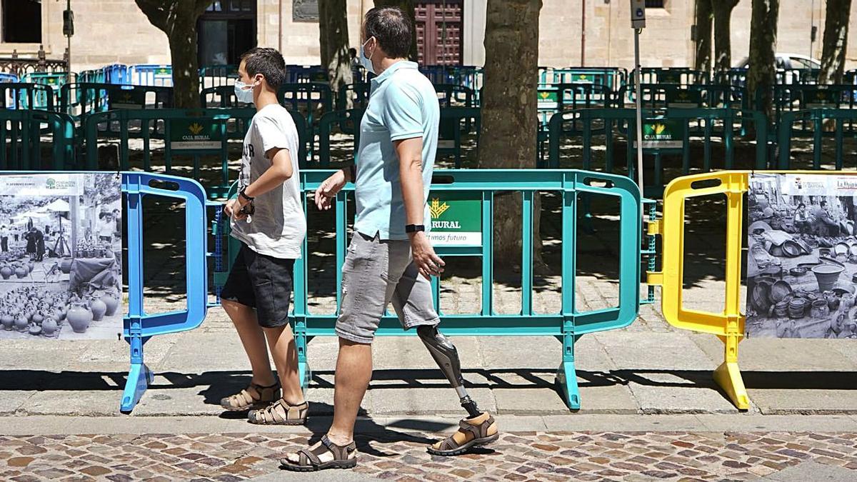 Dos personas pasean por la zona donde se instalarán los puestos este sábado. |