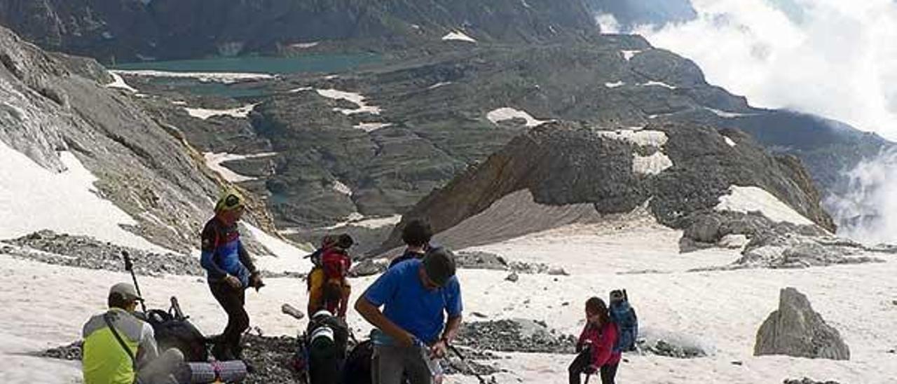 Los participantes toman un descanso tras cruzar el glaciar del Perdido, con el Lago de Marboré y Pico Pineta al fondo.