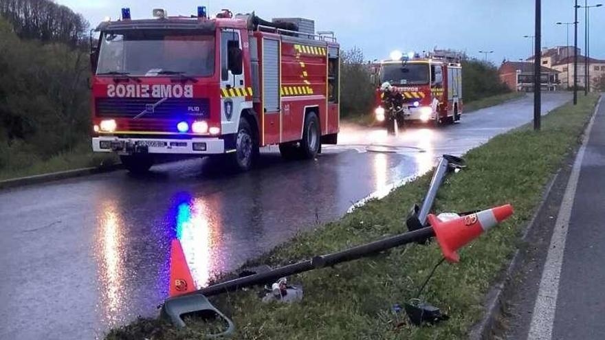 Efectivos de Emerxencias y bomberos limpian la vía tras el choque.