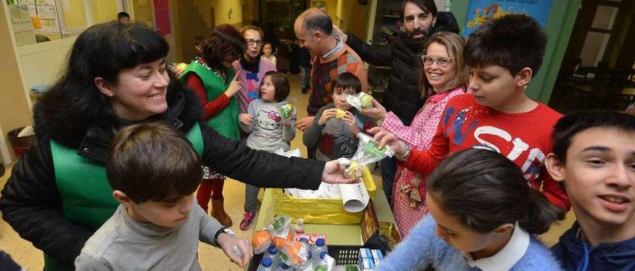 Voluntarios de la Aecc dan frutas a alumnos del CEIP Barcelos. // Gustavo Santos