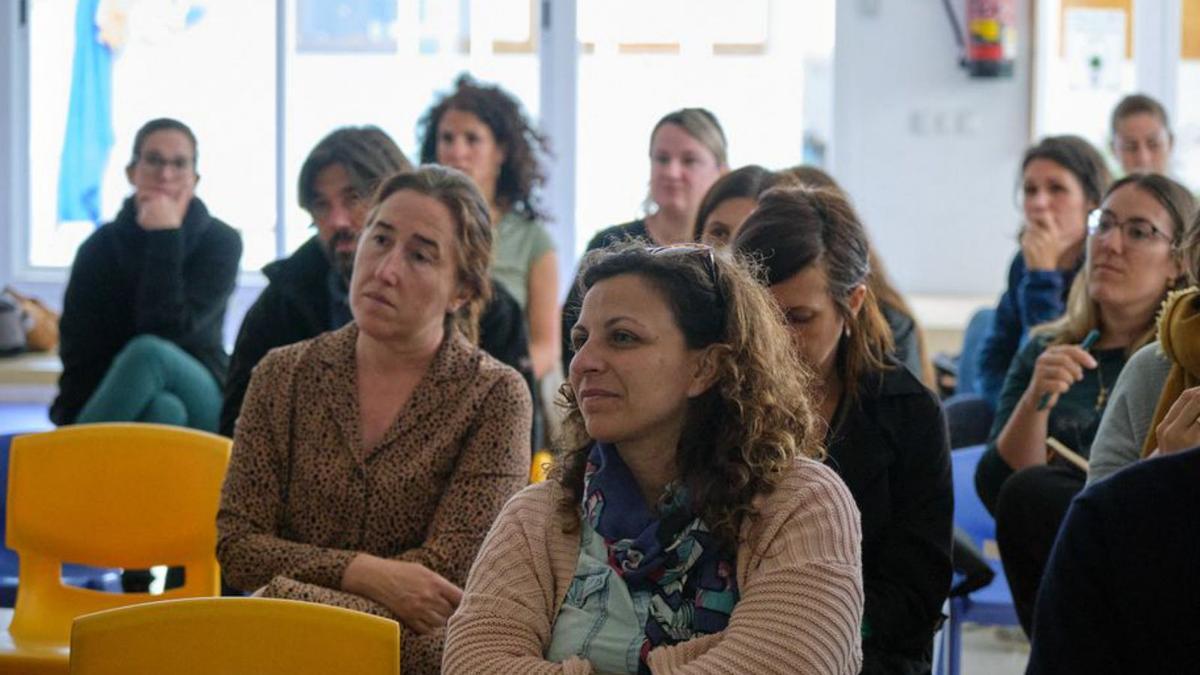 Un grup de mares i personal docent escolten Castro.