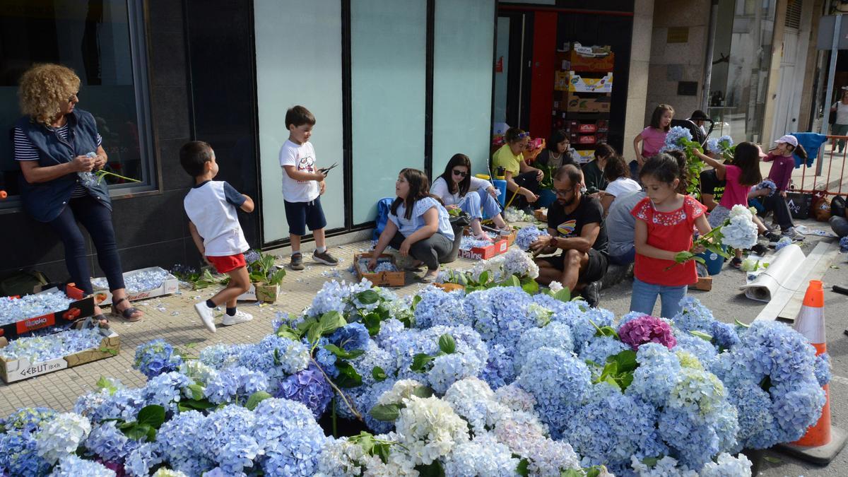 Vecinos de Bueu trabajando ayer por la tarde en la preparación del material para las alfombras del Corpus.