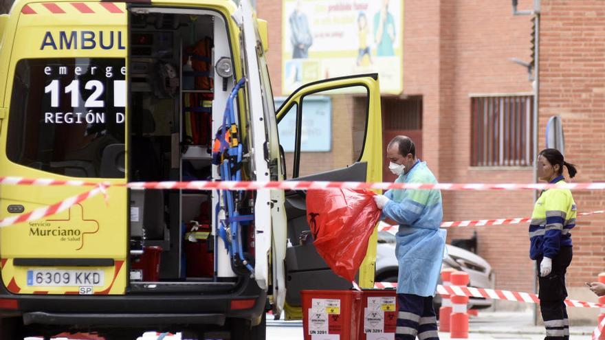 Dos sanitarios desinfectan una ambulancia