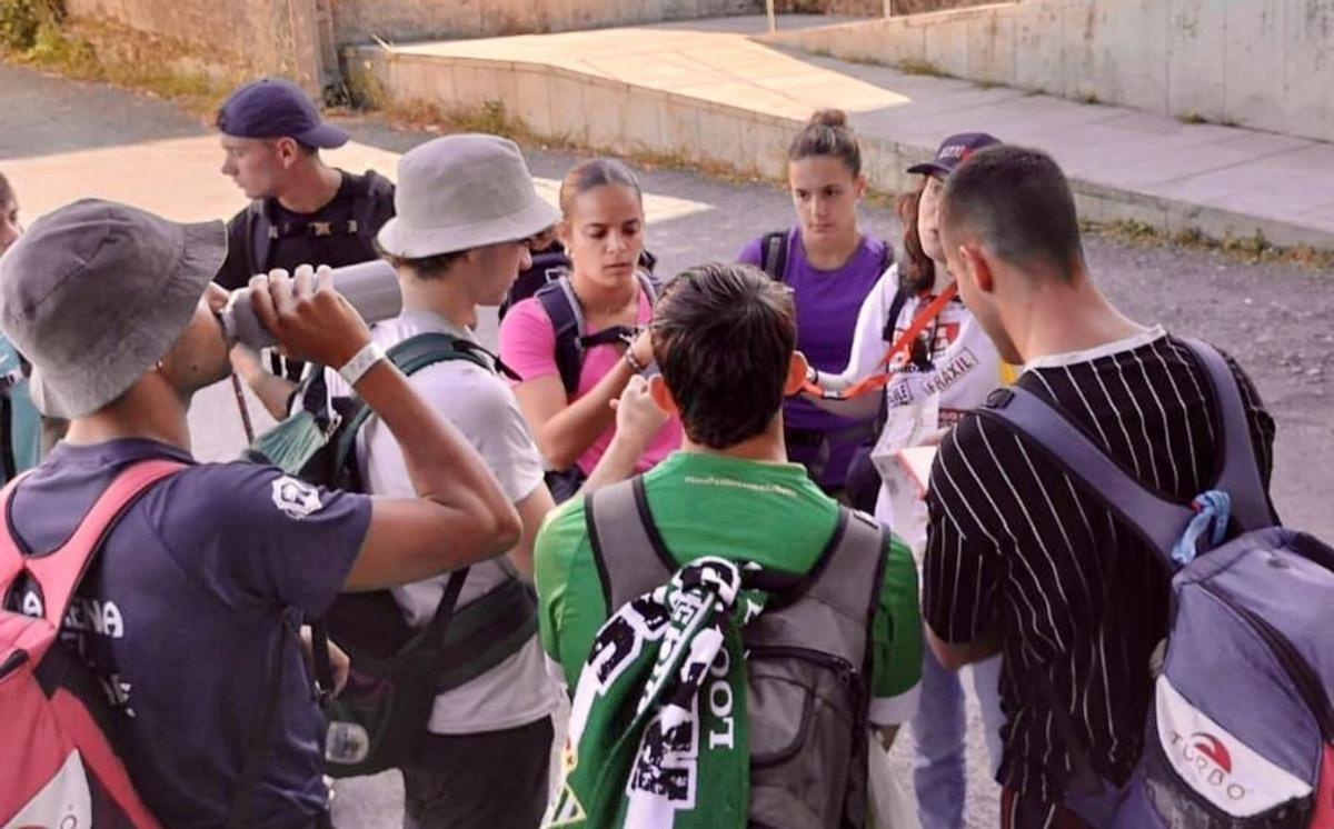 Una informadora de la campaña de buenas prácticas, ayer, con un grupo de jóvenes peregrinos / concello